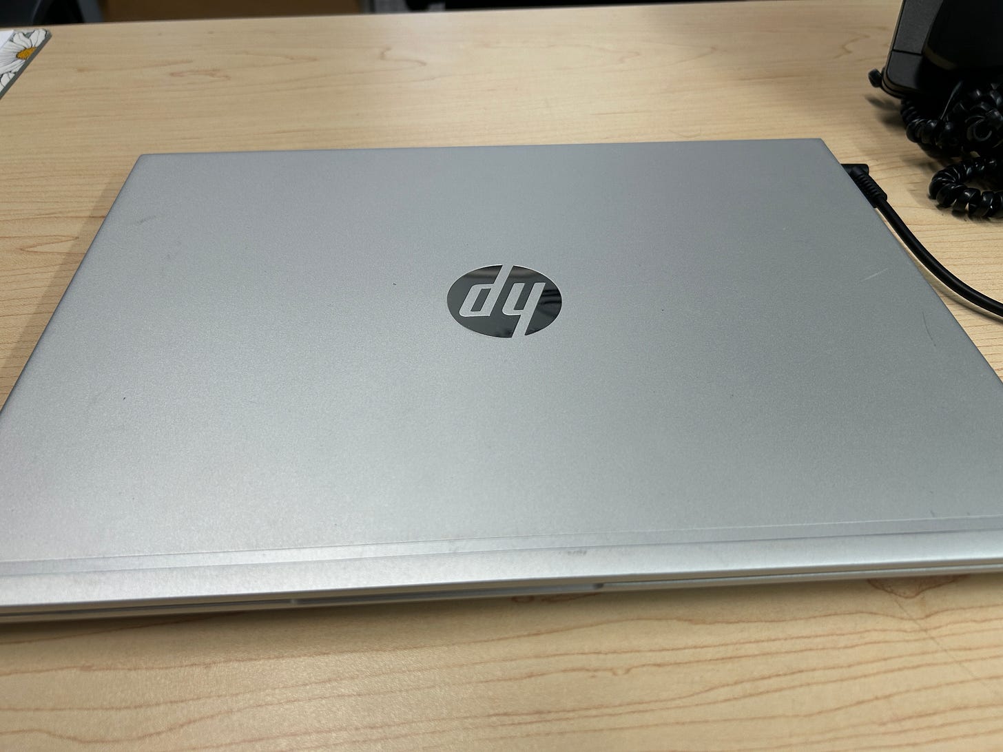 Photo of a laptop on a light-colored wood desk.