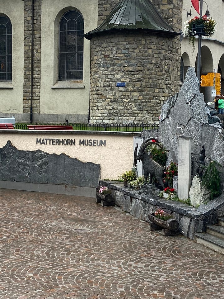 One of the plaques in the Walk of Climb, the Ibex fountain and the Matterhorn Museum, the Marmot fountain, and the Bronze Alphorn, which is pointed directly at the Matterhorn