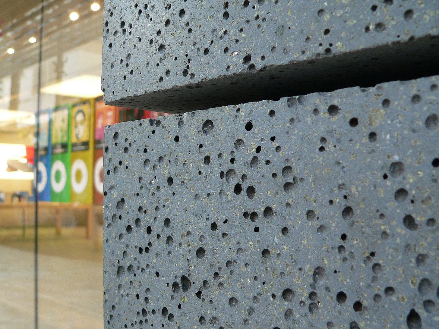 The exterior of Apple Royal Hawaiian at opening. The photo is a macro shot of the dark stone covering the store facade.