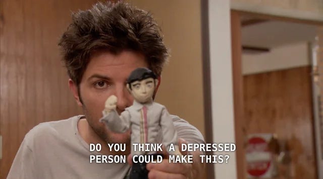 Ben from Parks and Recreation, looking dishevelled, tired and distressed. He's holding a doll up to the screen and captions read "do you think a depressed person could make this?" Ben from Parks and Recreation, looking dishevelled, tired and distressed. He's holding a doll up to the screen and captions read "do you think a depressed person could make this?"