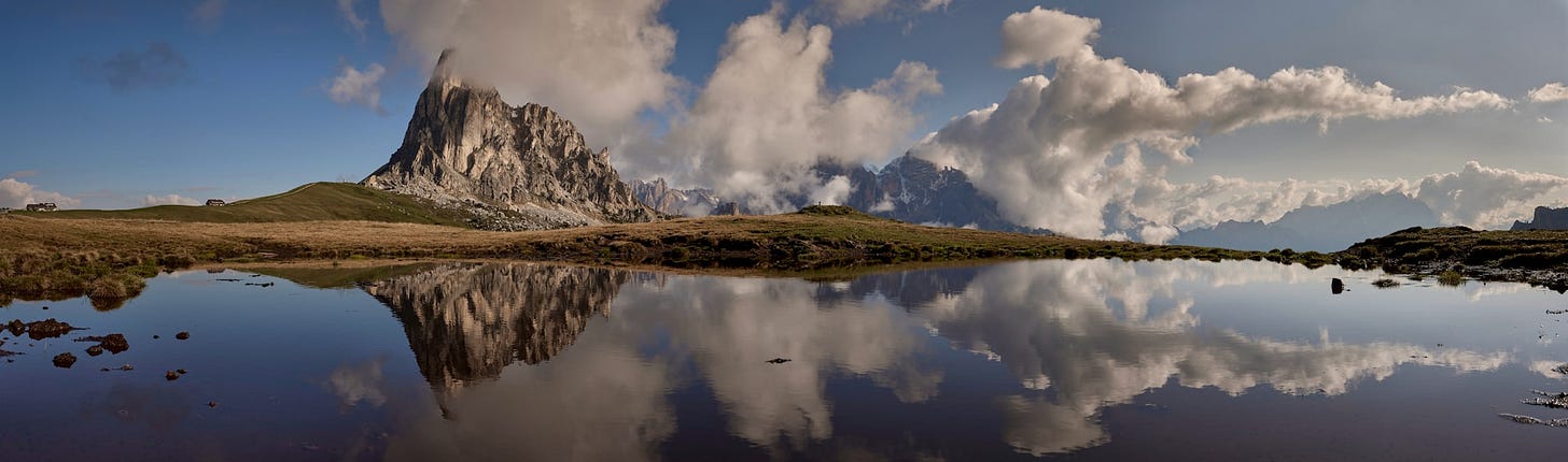 A mountain is reflected in the still water of a lake