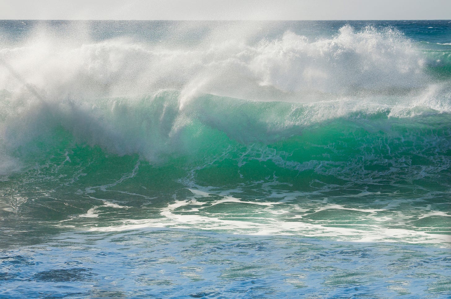 Foaming aqua-coloured waves crashing against the shore.