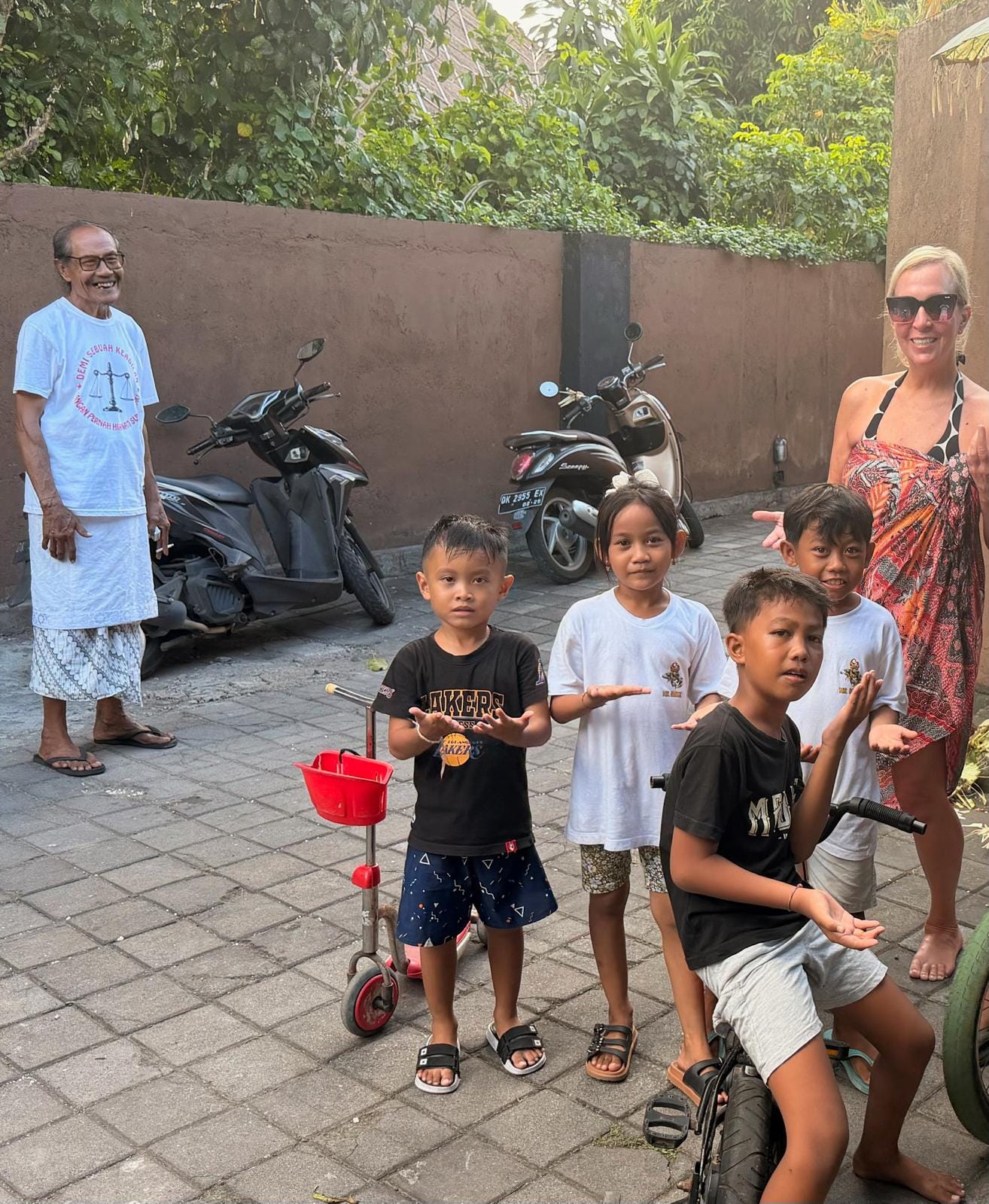 Children and neighbors gathered beside a family compound in Sanur, Bali.