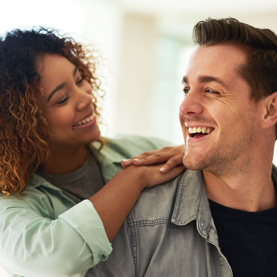 happy-man-woman-together-home-love-romance-affection-living-room-interracial-couple-happin