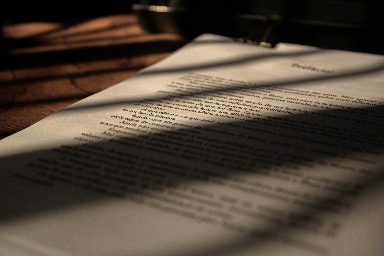 Documento scritto appoggiato su un tavolo di legno e illuminato da una luce tagliente solare tagliente, che ne lascia alcune strisce oblique in ombra. Documento scritto appoggiato su un tavolo di legno e illuminato da una luce tagliente solare tagliente, che ne lascia alcune strisce oblique in ombra.