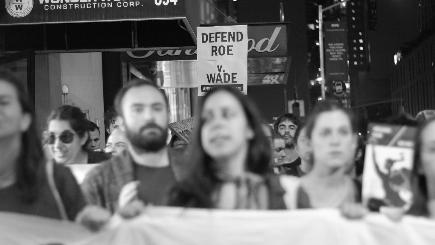 Black and white photo of marchers protesting in defense of Roe v. Wade Black and white photo of marchers protesting in defense of Roe v. Wade