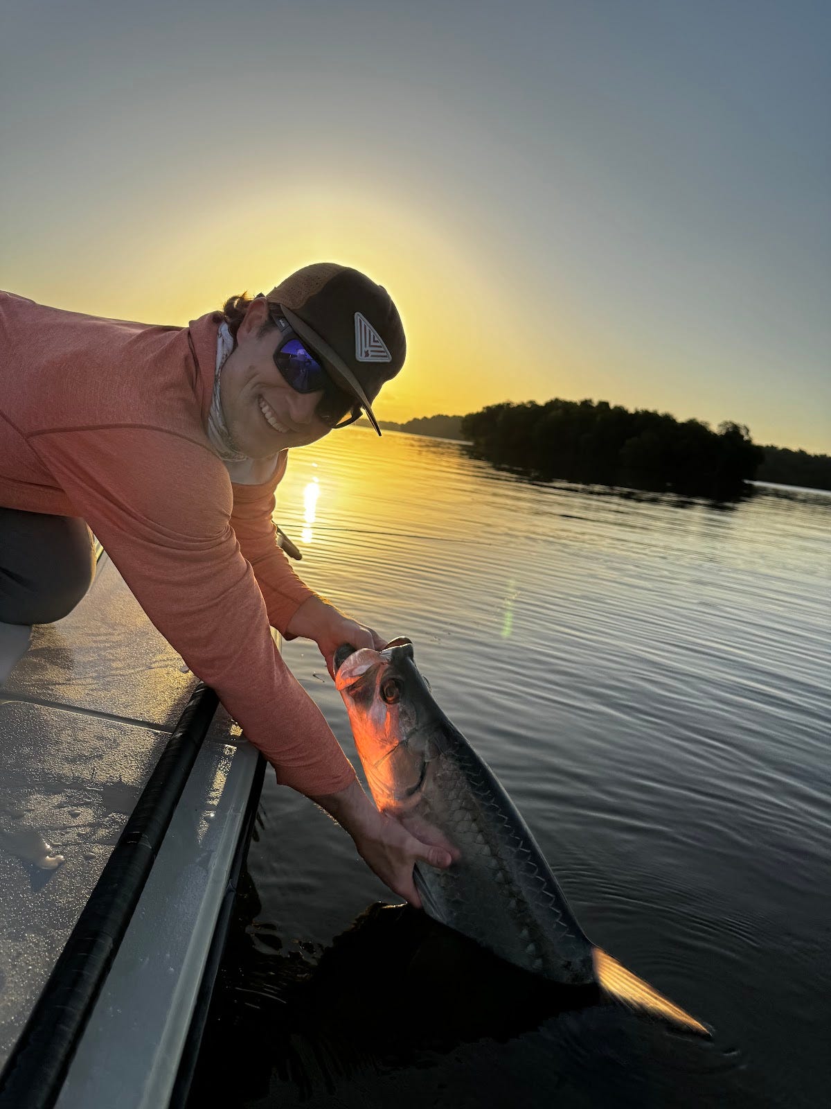 Josh lands a magnificent tarpon on the first morning of the trip, showcasing the thrill of hooking the elusive Silver King in the calm Everglades waters.