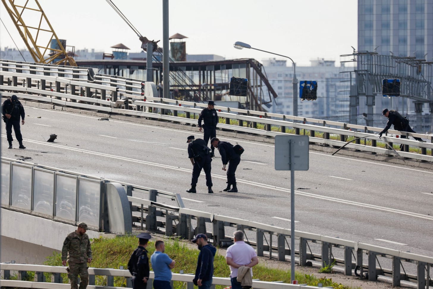 Members of the security services collect debris as they investigate near the site of a damaged building following a reported drone attack in Moscow, Russia, on Monday, July 24. 