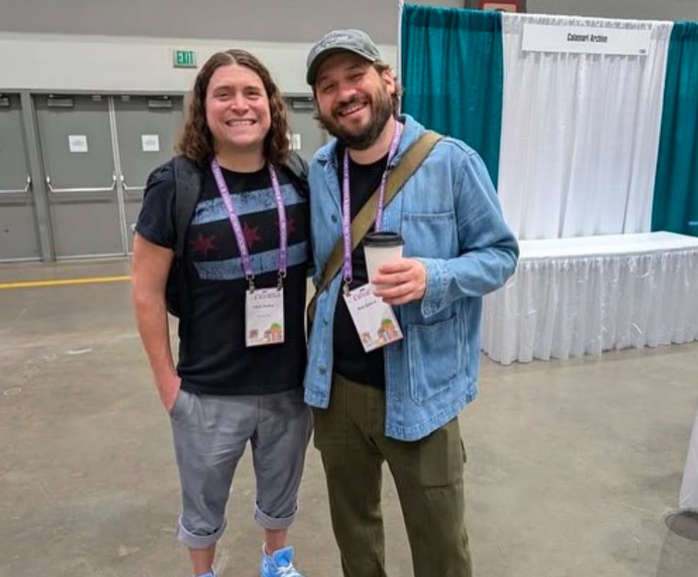 two white men with shaggy hair, arms around each other's backs, cheesin at the camera.