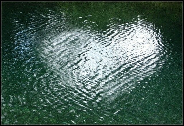 This may contain: the water is green with ripples in it