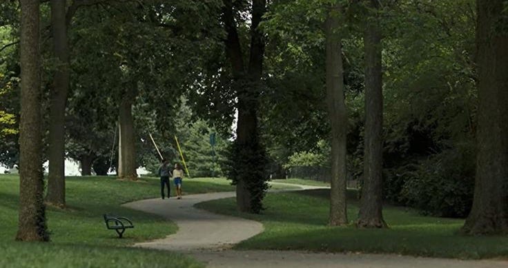 This may contain: a person walking down a path in the park