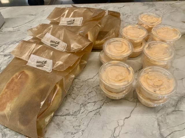 Packaged bags with the words NIIICE on them, and small plastic containers of cream
