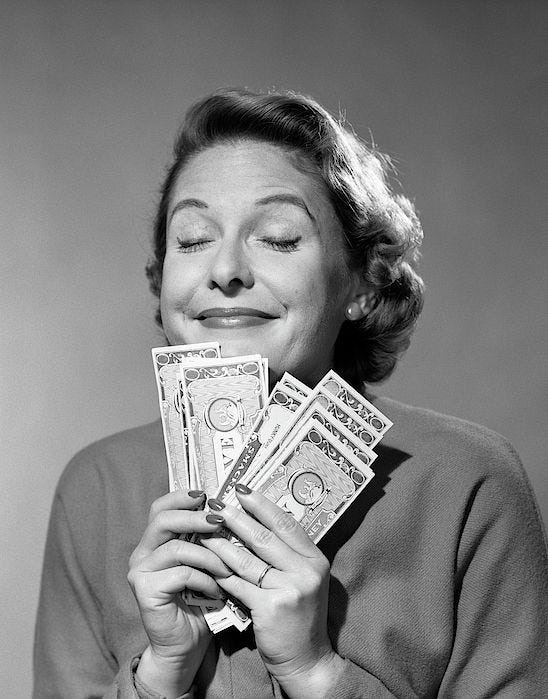 This may contain: an old photo of a woman holding money