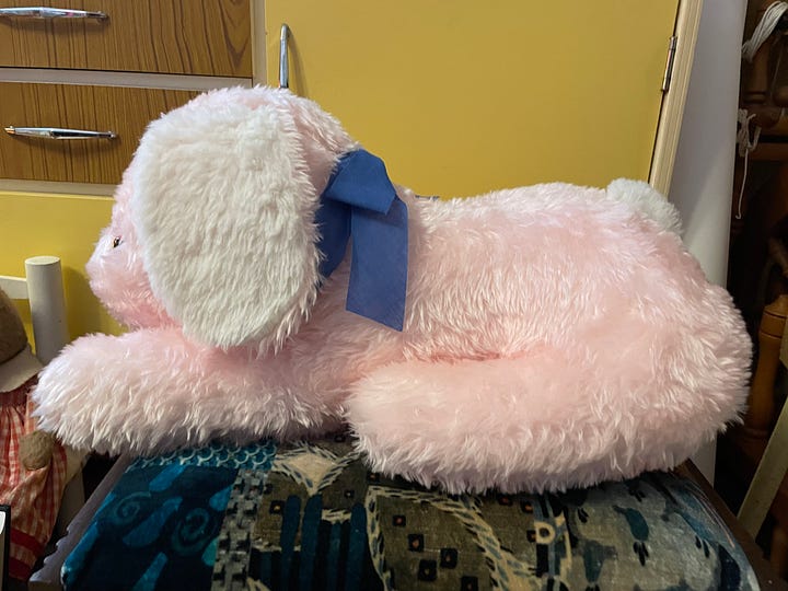 A large pink plush dog seen from the front and side.