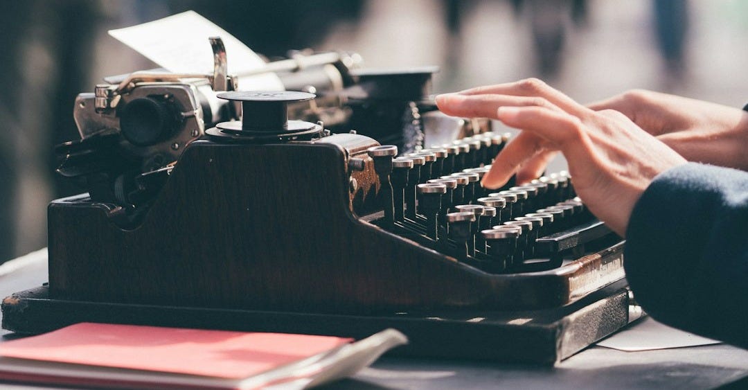 person using black typewriter person using black typewriter