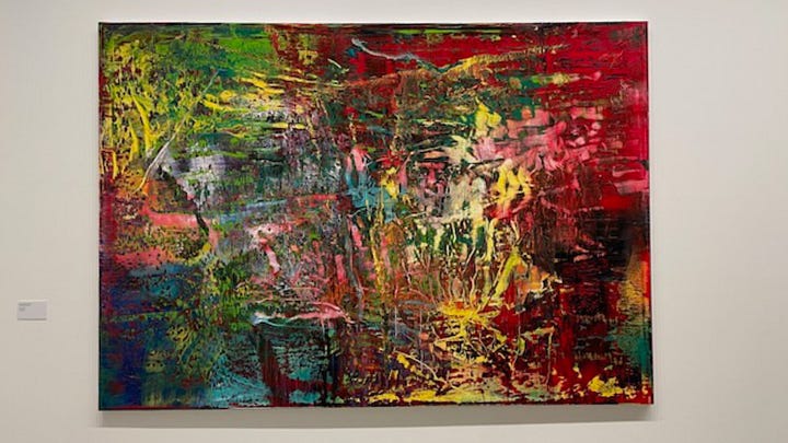 A colorful painting by artist Gerhard Richter, with splashes of yellow, green, blue, orange, pink and red, evoking a sense of joy.