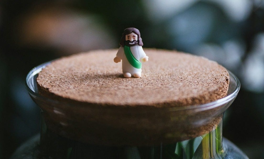 A small figurine is placed on top of a jar