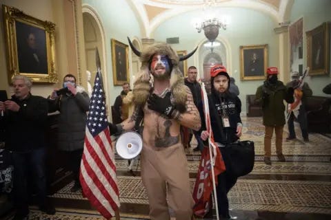 A person with horns and a horn holding a megaphone and a flag

AI-generated content may be incorrect.