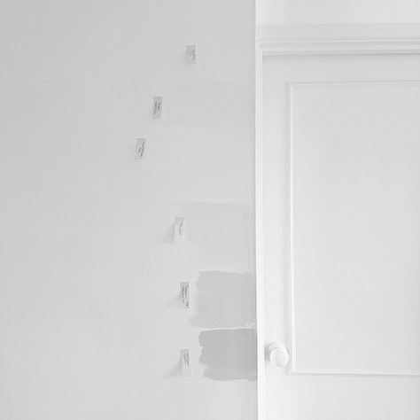 Photographs of a white door and wall with paint samples of different white paints with orange post it notes labelling the paint colours