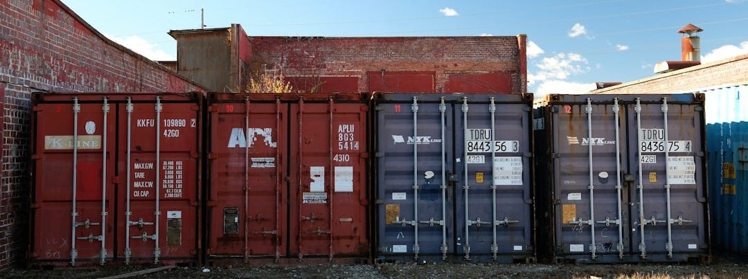 Shipping containers lined up against brick buildings