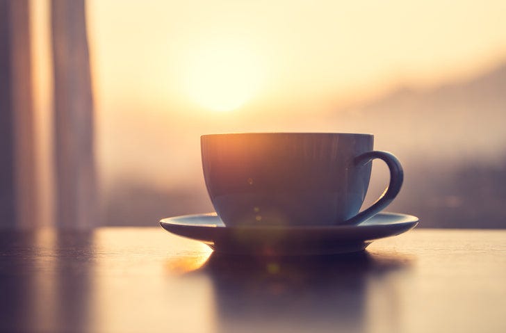 mug of coffee on table against the sunrise mug of coffee on table against the sunrise