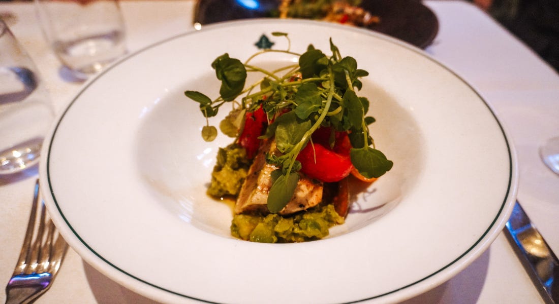 A close-up of a white plate of food with tuna and avocado, and cutlery and a white tablecloth underneath A close-up of a white plate of food with tuna and avocado, and cutlery and a white tablecloth underneath