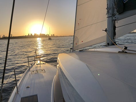 Collage of 3 sunsets over the water and one with the sun silhouting a city skyline