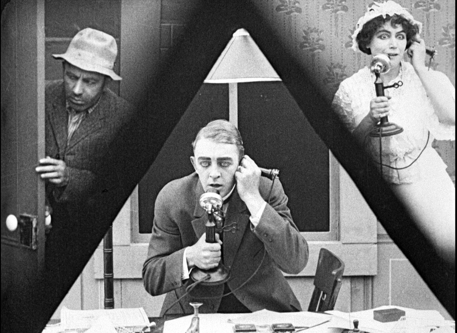 Still frame from Lois Weber's 1913 10-min silent thriller, featuring her unique use of a split screen that is split into 3 parts. The center is a triangle shape.