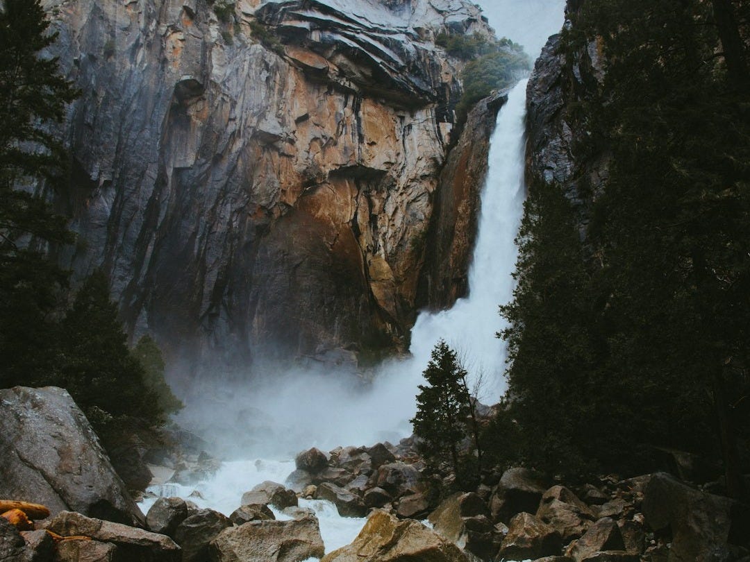 river stream between rocks during daytime river stream between rocks during daytime