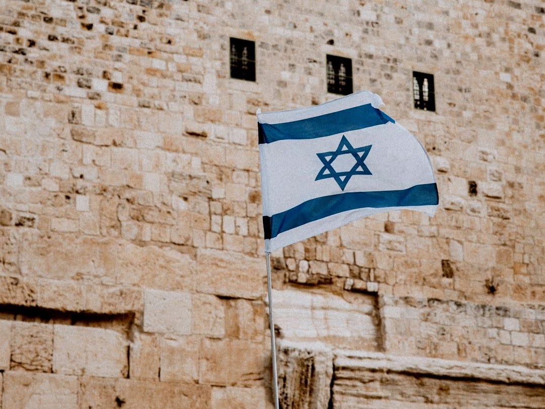 a flag flying in front of a stone building