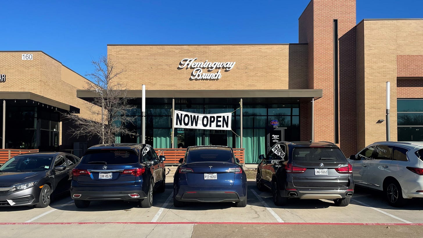 A "Now Open" banner hanging off a restaurant's facade