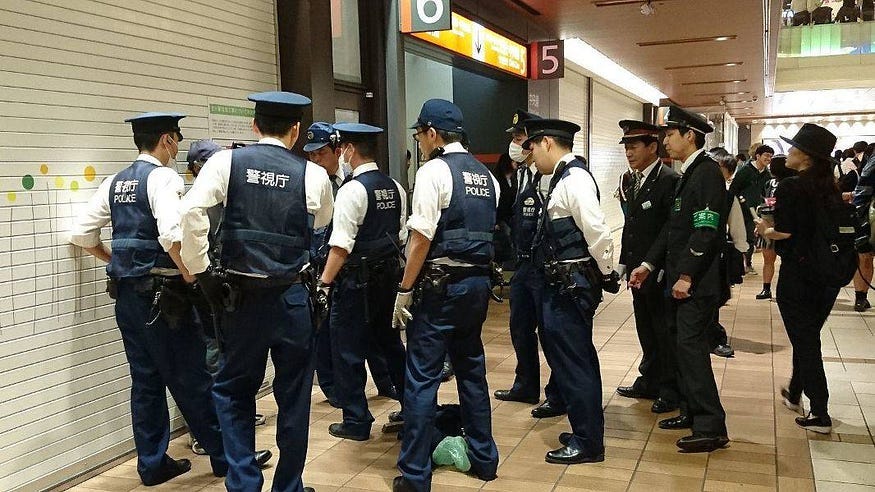 A group of Japanese police subduing a suspect A group of Japanese police subduing a suspect