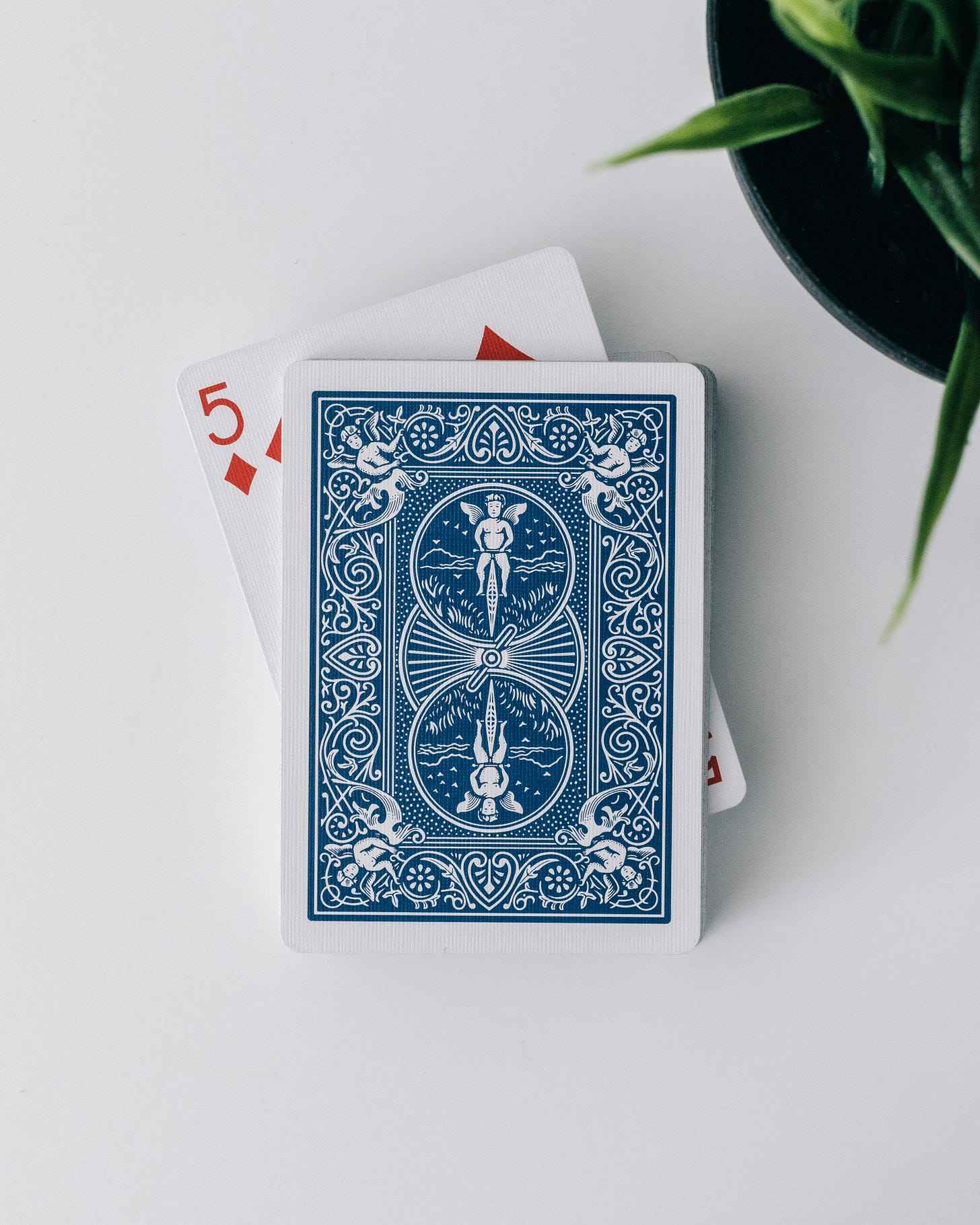 photo of front side of a playing card, a 5, and backside of another