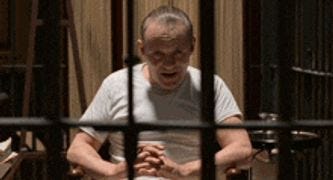 Un homme en chemise blanche est derrière les barreaux, dans une cellule. Un homme en chemise blanche est derrière les barreaux, dans une cellule.