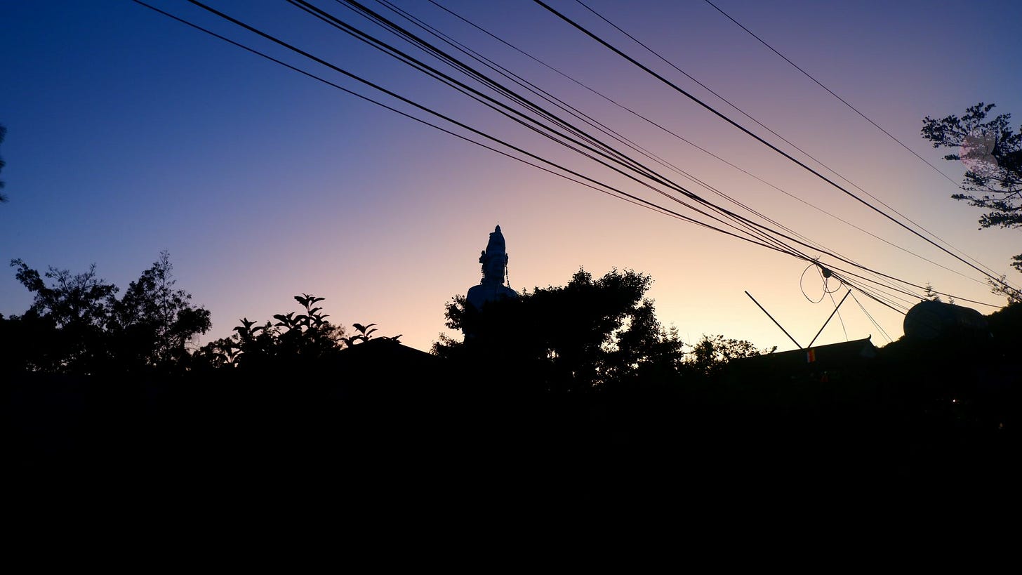 Silhouette of a female Buddha statue against a twilight sky, with soft hues of blue, ink, and gold blending in the background. Silhouette of a female Buddha statue against a twilight sky, with soft hues of blue, ink, and gold blending in the background.