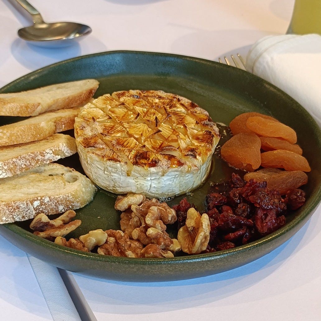 Baked Brie with walnuts, honey, crostini, dried apricots, and raisins
