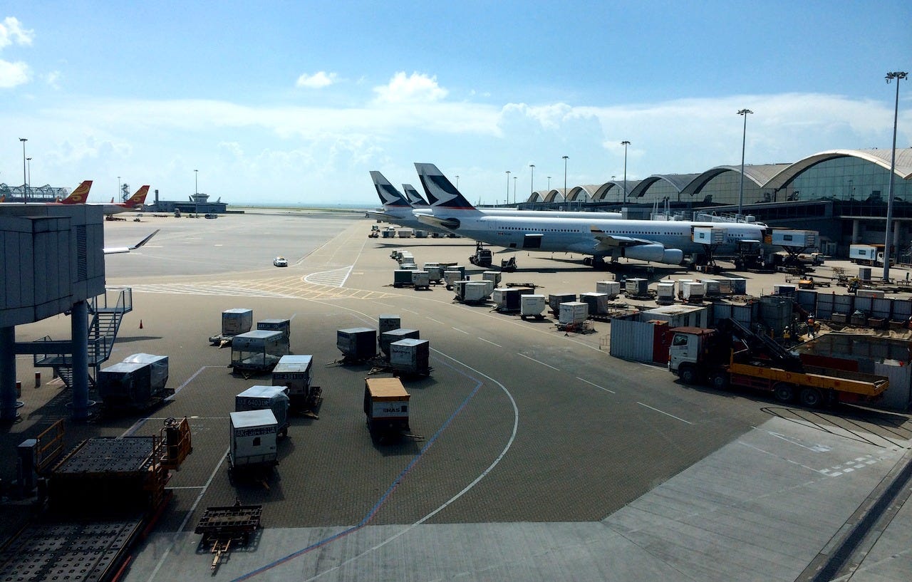 Three Cathay Pacific aircraft lined up on the tarmac at Hong Kong International Airport