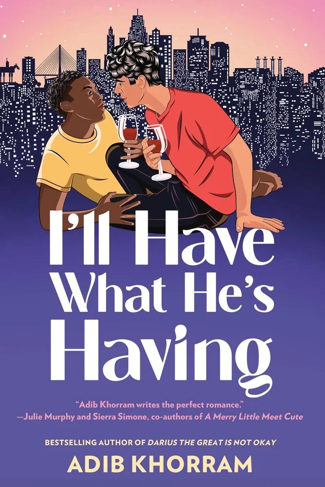 The book cover for I'll HAVE WHAT HE'S HAVING by Adib Khorram. The cover shows two men cozied up with glasses of wine, with a cityscape in the background.