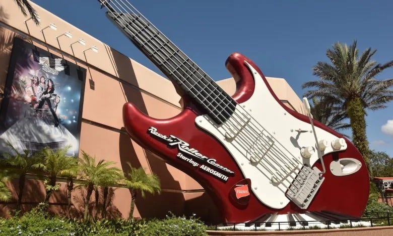 a red and white guitar statue in front of a building