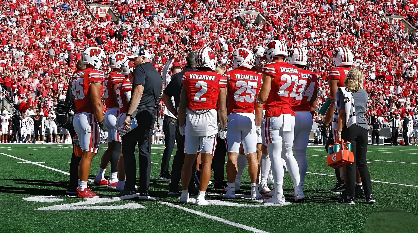 Wisconsin Badgers football players stand on the field at Camp Randall Stadium. Wisconsin Badgers football players stand on the field at Camp Randall Stadium.