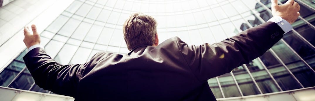 low-angle photography of man in the middle of buidligns
