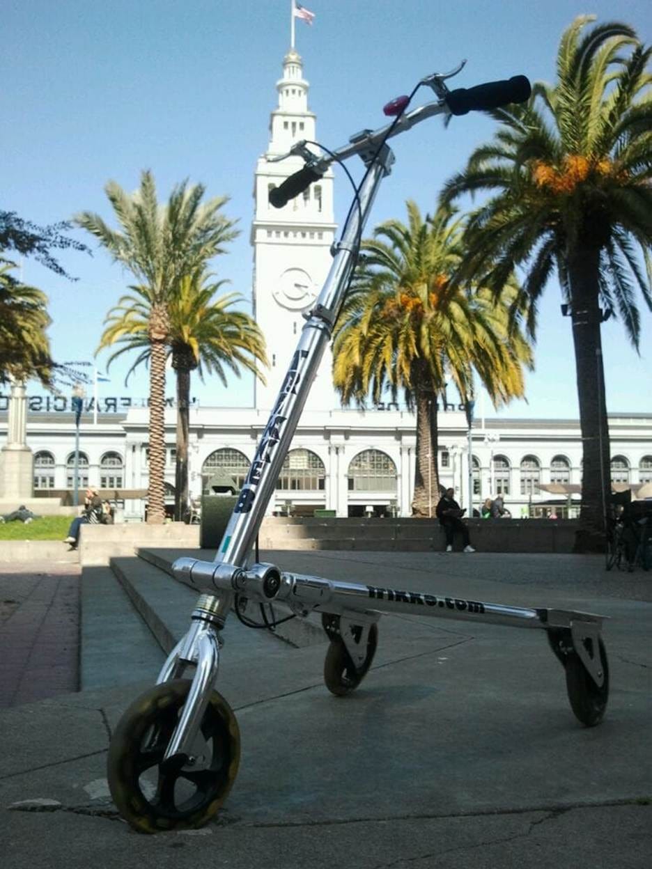 A scooter with wheels and a tower in the background

AI-generated content may be incorrect.