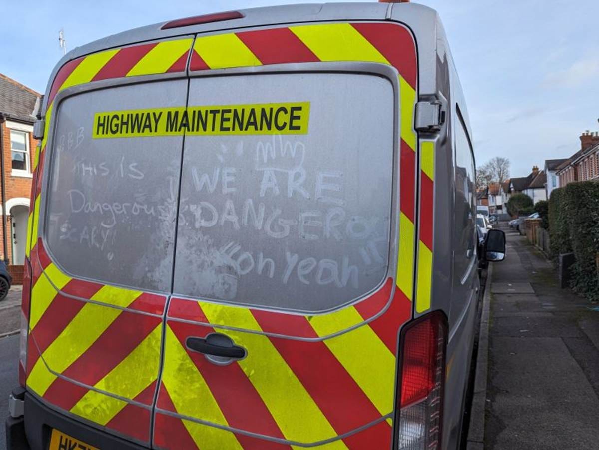 Handwritten messages inscribed in the dirt on the back of a grubby white van.