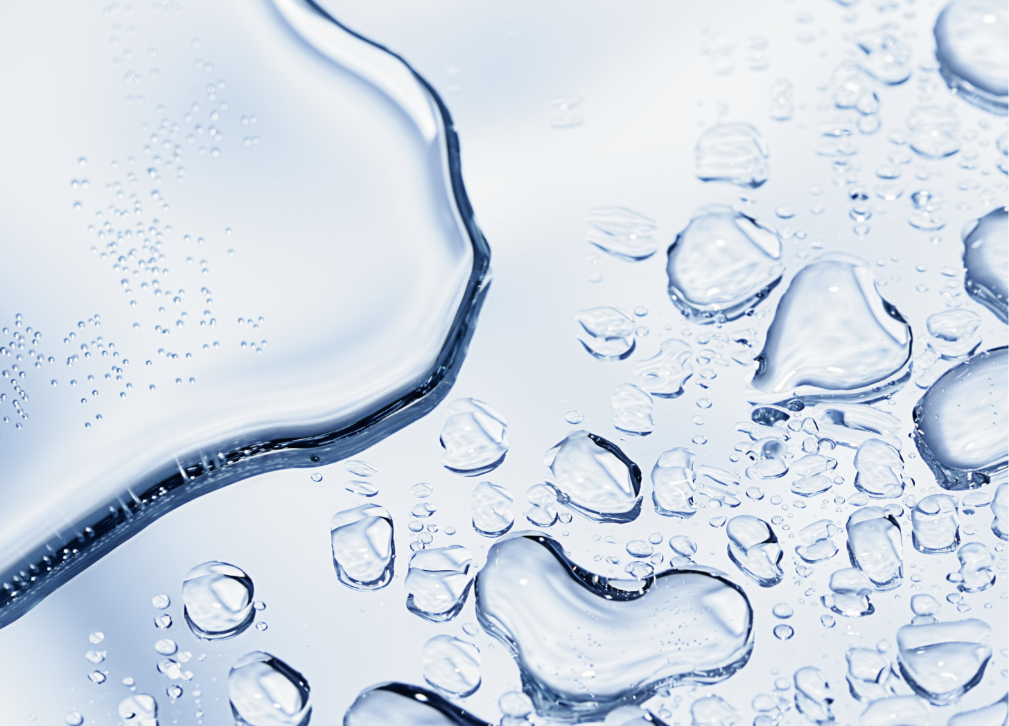 Close-up of water droplets suspended above rippling blue water. Close-up of water droplets suspended above rippling blue water.