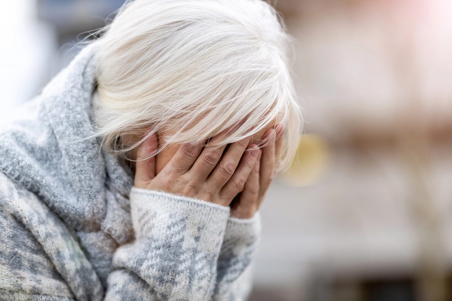 Elderly woman with face in her hands weeping Elderly woman with face in her hands weeping