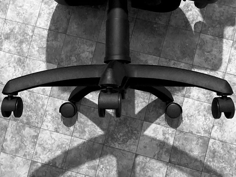 A close-up of the bottom of a swivel chair on its side. 