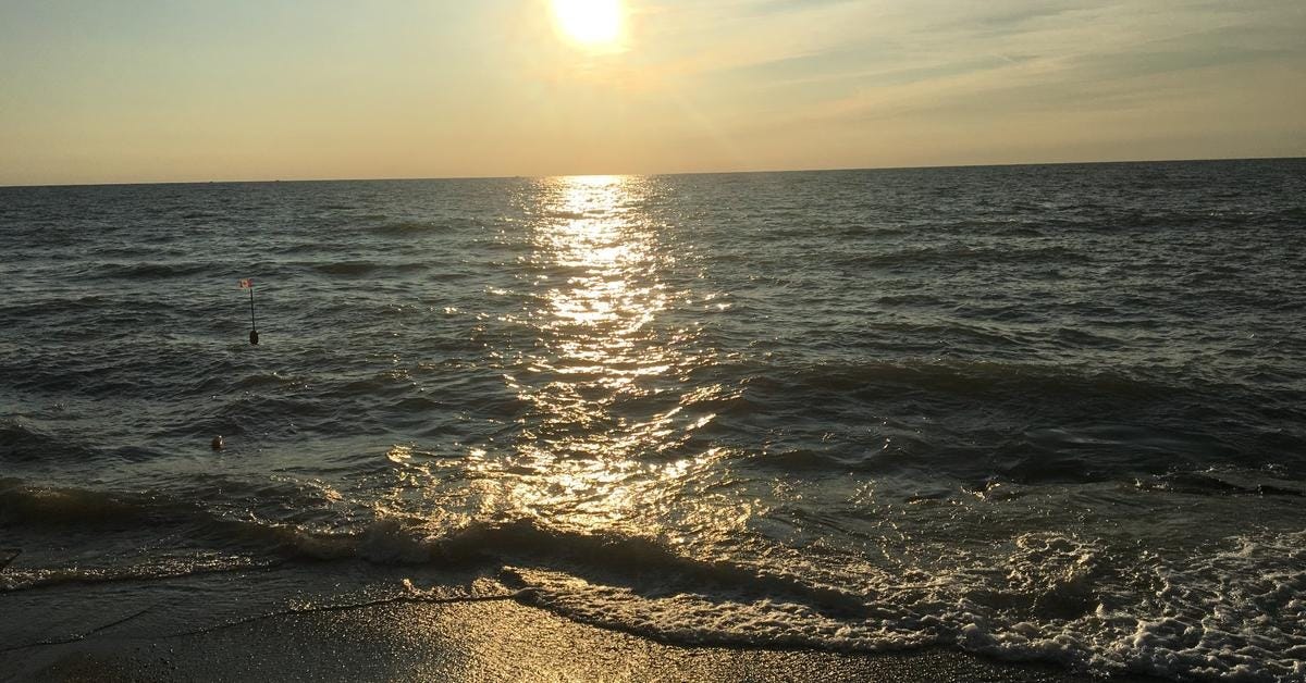 Sunset over Lake Ontario with the quote: ‘Clarity isn’t just a luxury. It’s a form of courage.’ Quote by Canadian writer Leni Spooner for Between the Lines.