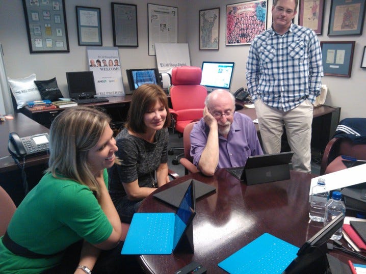 A photo of 3 people at a desk looking at Surface computers with Touch and Type covers. They are smiling a lot. One person is standing looking over them. A photo of 3 people at a desk looking at Surface computers with Touch and Type covers. They are smiling a lot. One person is standing looking over them.