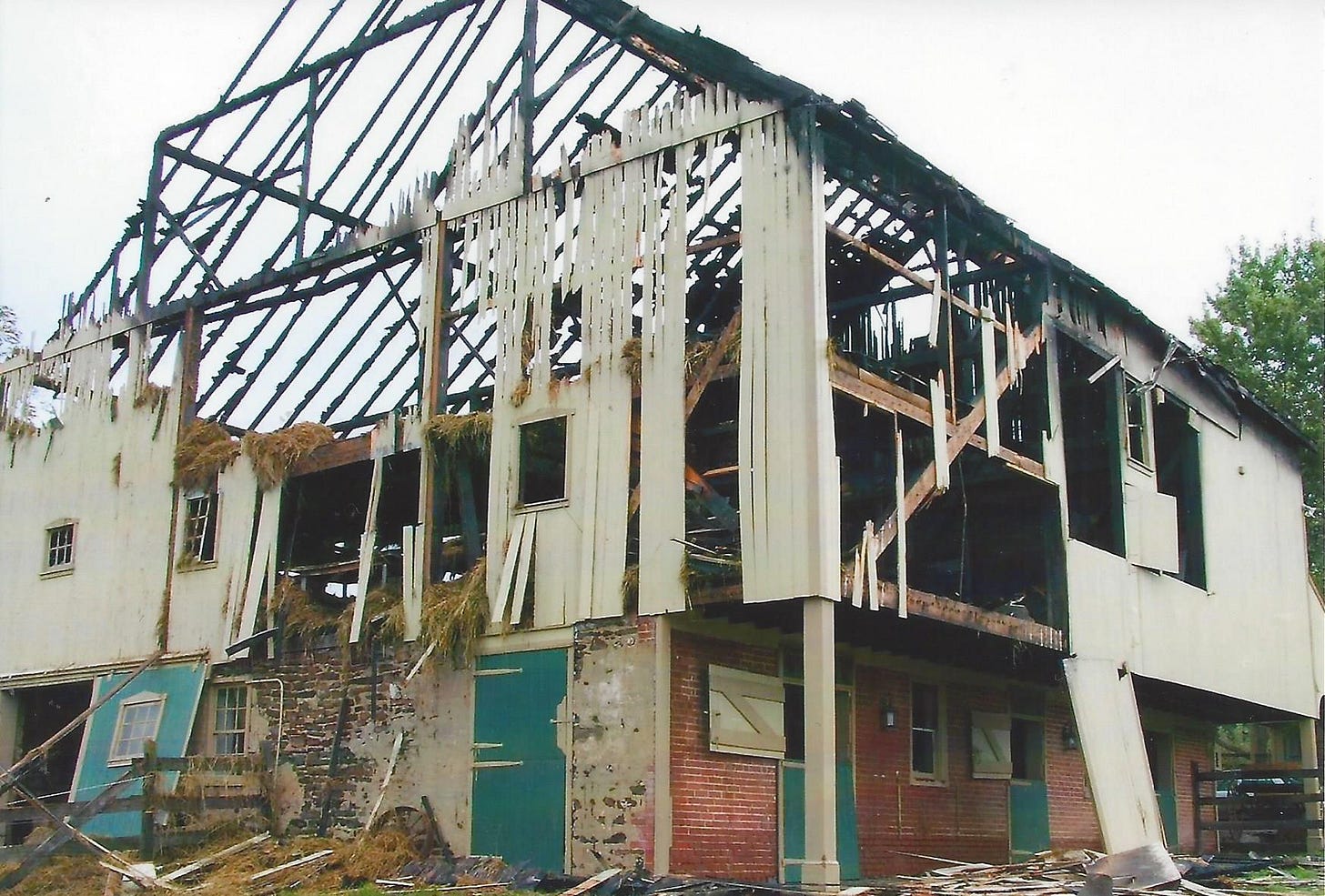 The remains of a large barn that has been severely damaged by fire The remains of a large barn that has been severely damaged by fire