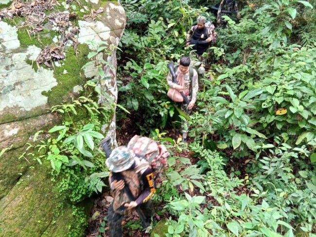 3 gardes forestiers en tenue camouflage enfoncés dans la jungle jusqu'au cou